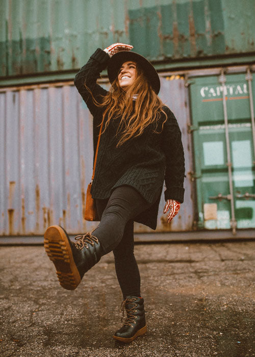 Influencer wearing black sweater, jeans and hat walking outside wearing Cougar Original Pillow Boot in Black